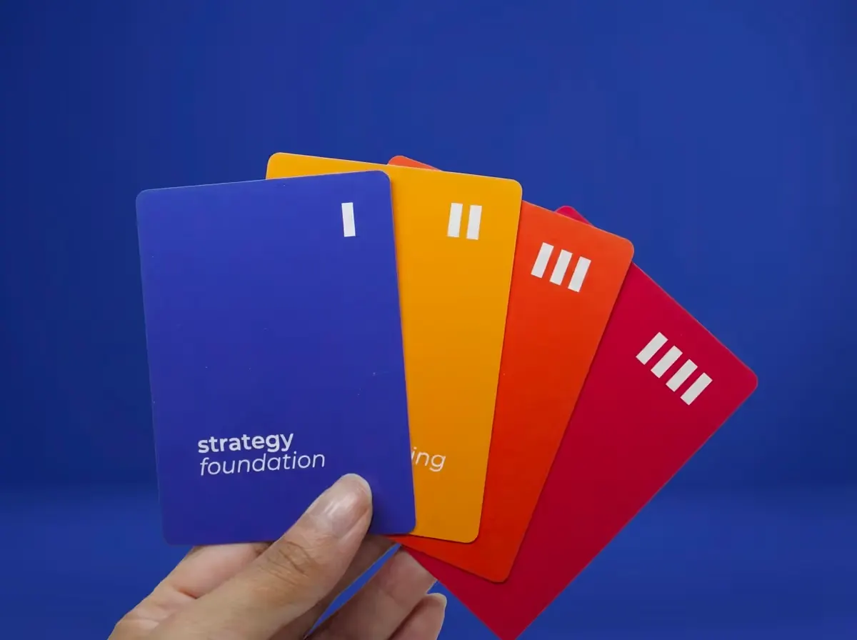 A hand holding the four Strategy suites: Foundation, Understanding, Resolution and Action